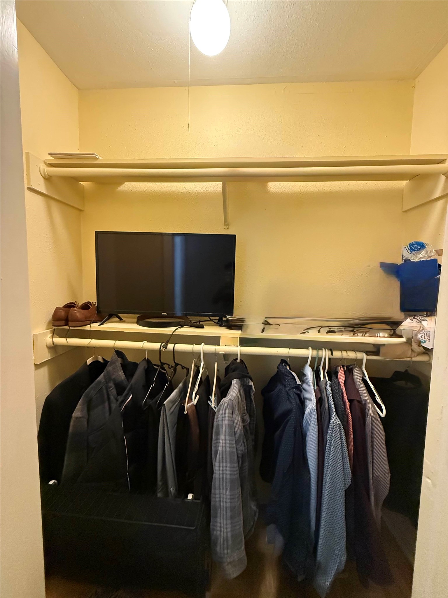 7047 Bissonnet Street, Unit 32 Houston, TX 77074 - Photo 16 of 19 a view of walk in closet with clothes and shoes