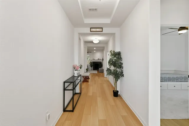 a view of a hallway with wooden floor and furniture