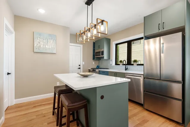 a kitchen with stainless steel appliances granite countertop a sink refrigerator and microwave