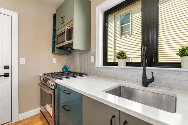a kitchen with stainless steel appliances granite countertop a sink and a stove