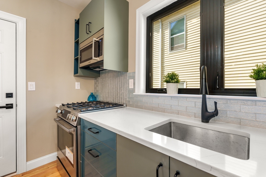 58 Dustin Street, Unit 1 Boston, MA 02135 - Photo 9 of 29 a kitchen with stainless steel appliances granite countertop a sink and a stove