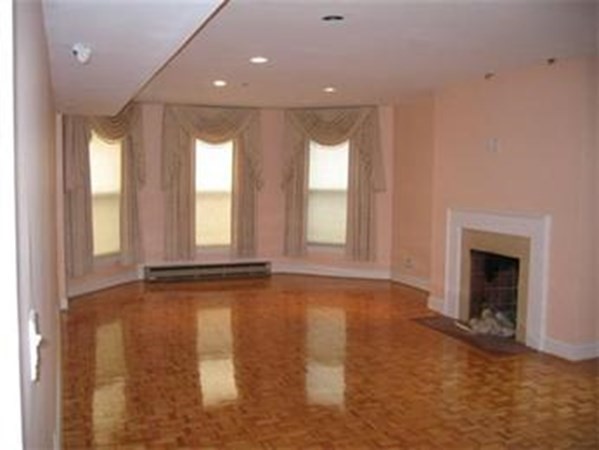 416 Commonwealth Avenue, Unit 507 Boston, MA 02215 - Photo 2 of 5 a view of an empty room with a fireplace and a window