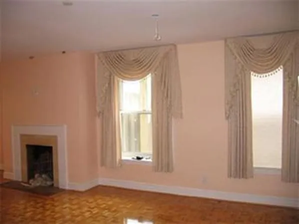 a view of a small space with wooden floor and a window