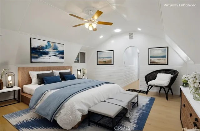 a bedroom with a bed lamp and paintings on the wall