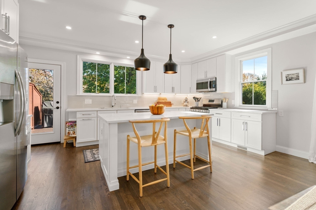 35 Algonquin Road, Unit 35 Chestnut Hill, MA 02467 - Photo 5 of 38 a kitchen with stainless steel appliances granite countertop a stove a refrigerator a oven a sink with island chairs and wooden floor
