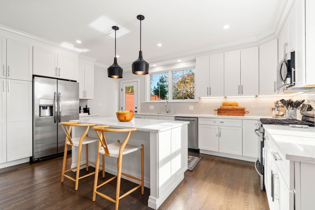 35 Algonquin Road, Unit 35 Chestnut Hill, MA 02467 - Photo 6 of 38 a kitchen with stainless steel appliances kitchen island granite countertop a stove a sink and a refrigerator