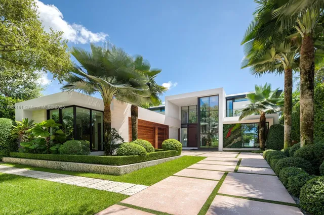a front view of a house with a garden and plants