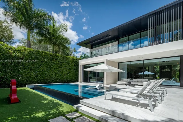 a view of house with swimming pool and sitting area