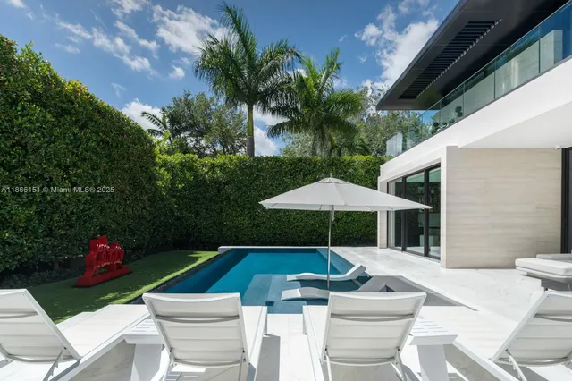 a view of a patio with couches table and chairs under an umbrella with a fire pit