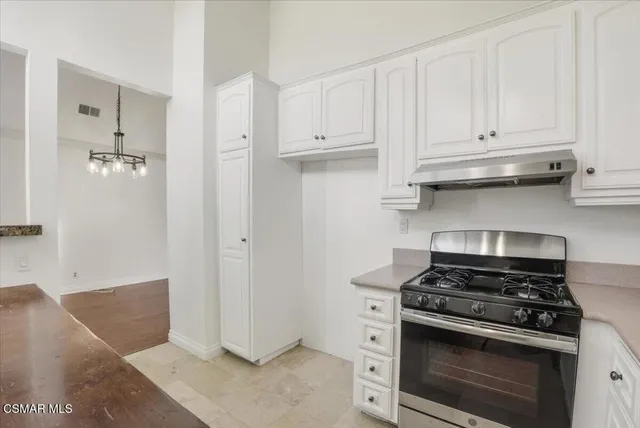 a stove top oven sitting inside of a kitchen