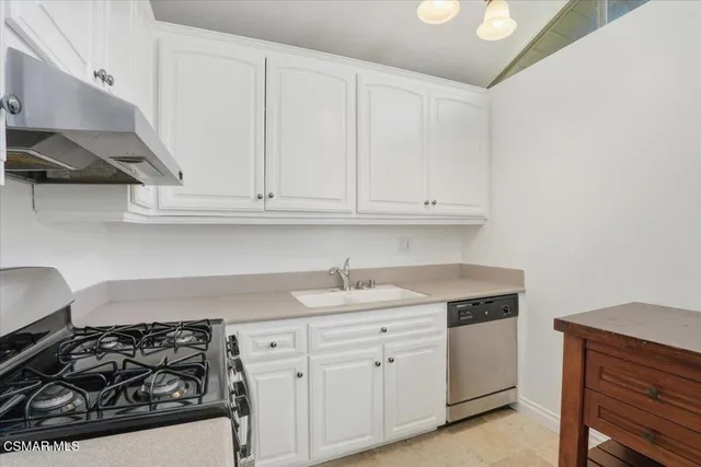 a kitchen with white cabinets and appliances