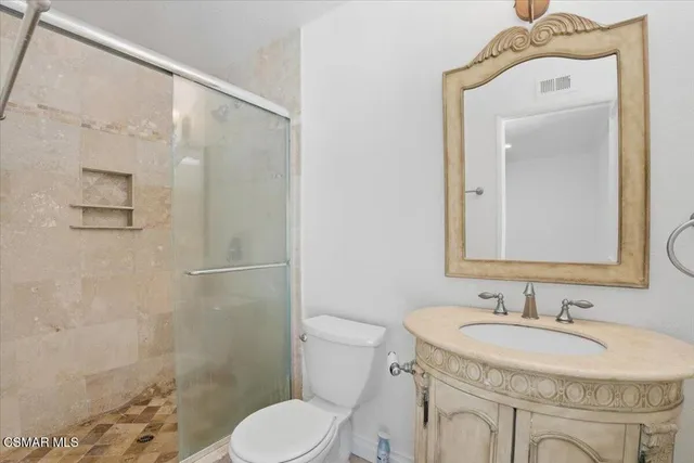 a bathroom with a sink toilet a mirror and shower