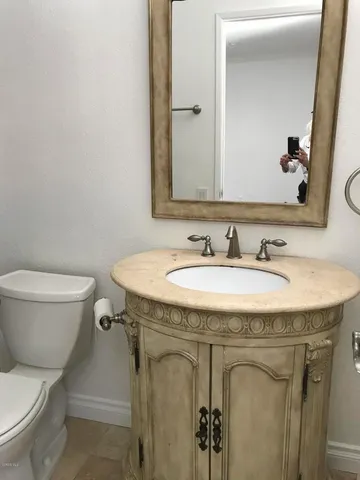 a bathroom with a granite countertop sink a toilet and a mirror