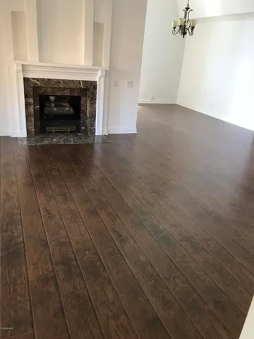 an empty room with wooden floor and fireplace