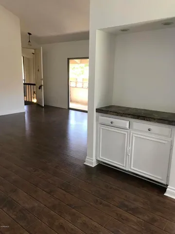 a kitchen with granite countertop white cabinets and a wooden floor