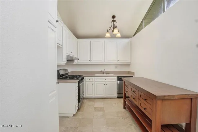 a kitchen with stainless steel appliances granite countertop a sink and a stove