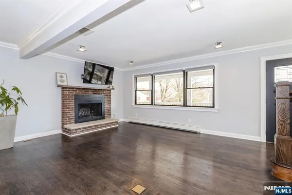 a view of an empty room with a window and fireplace