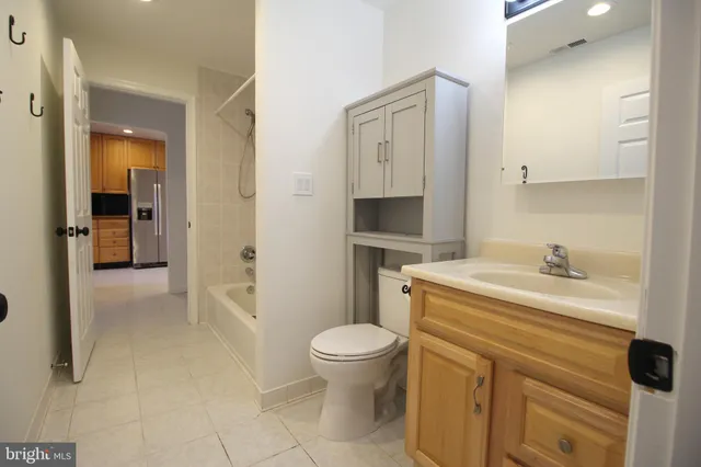 a bathroom with a granite countertop sink a toilet and a shower