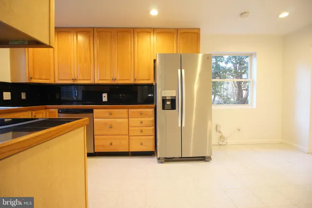 a kitchen with stainless steel appliances a refrigerator and a stove top oven