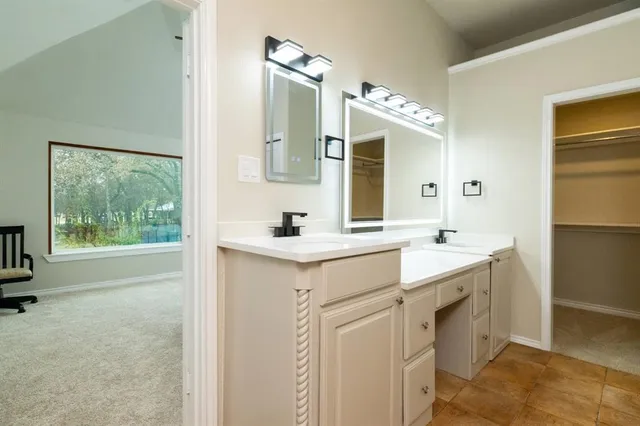 a spacious bathroom with a double vanity sink mirror and bathtub