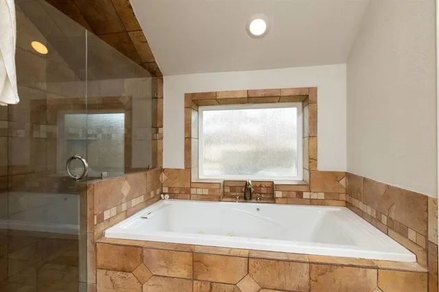 a bath tub sitting in a bathroom next to a window