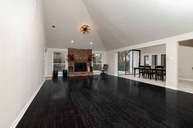 an empty room with wooden floor and fire place