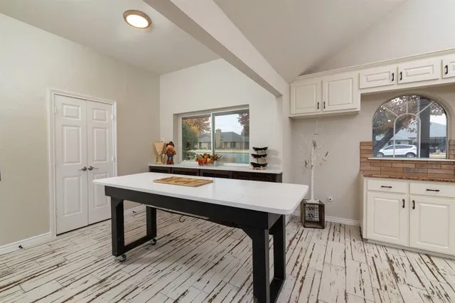 a kitchen with stainless steel appliances wooden floor dining table and chairs