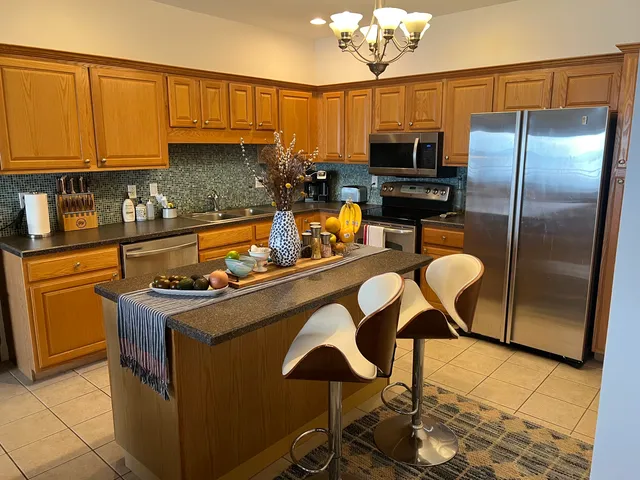 a kitchen with stainless steel appliances granite countertop a sink a stove and a refrigerator