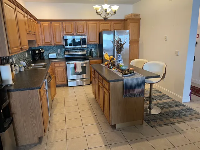 a kitchen with stainless steel appliances granite countertop a stove a sink and a refrigerator