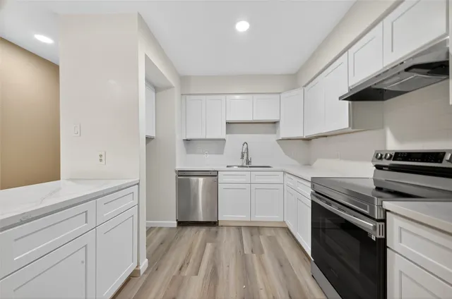 a kitchen with a sink stove and cabinets
