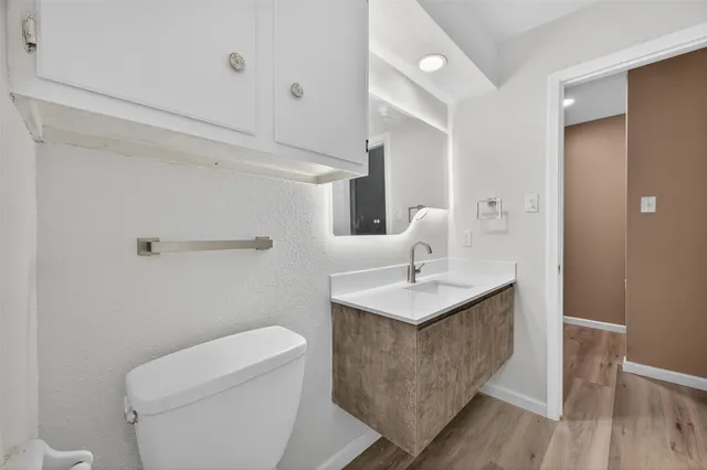 a bathroom with a toilet a sink a mirror and vanity