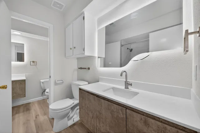 a bathroom with a sink a toilet and shower