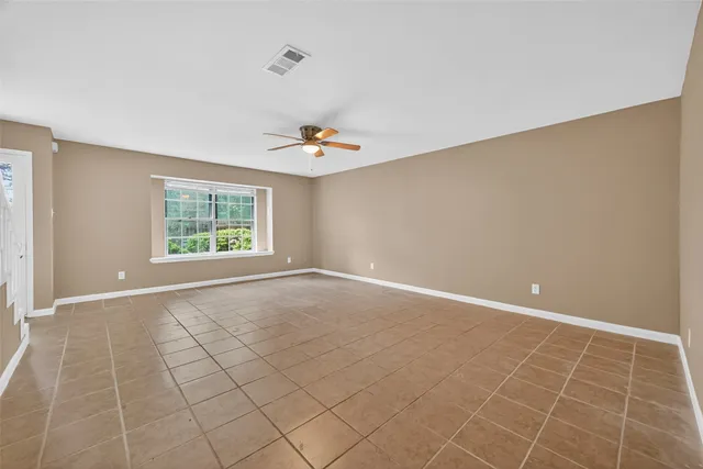 an empty room with a white walls and chandelier fan
