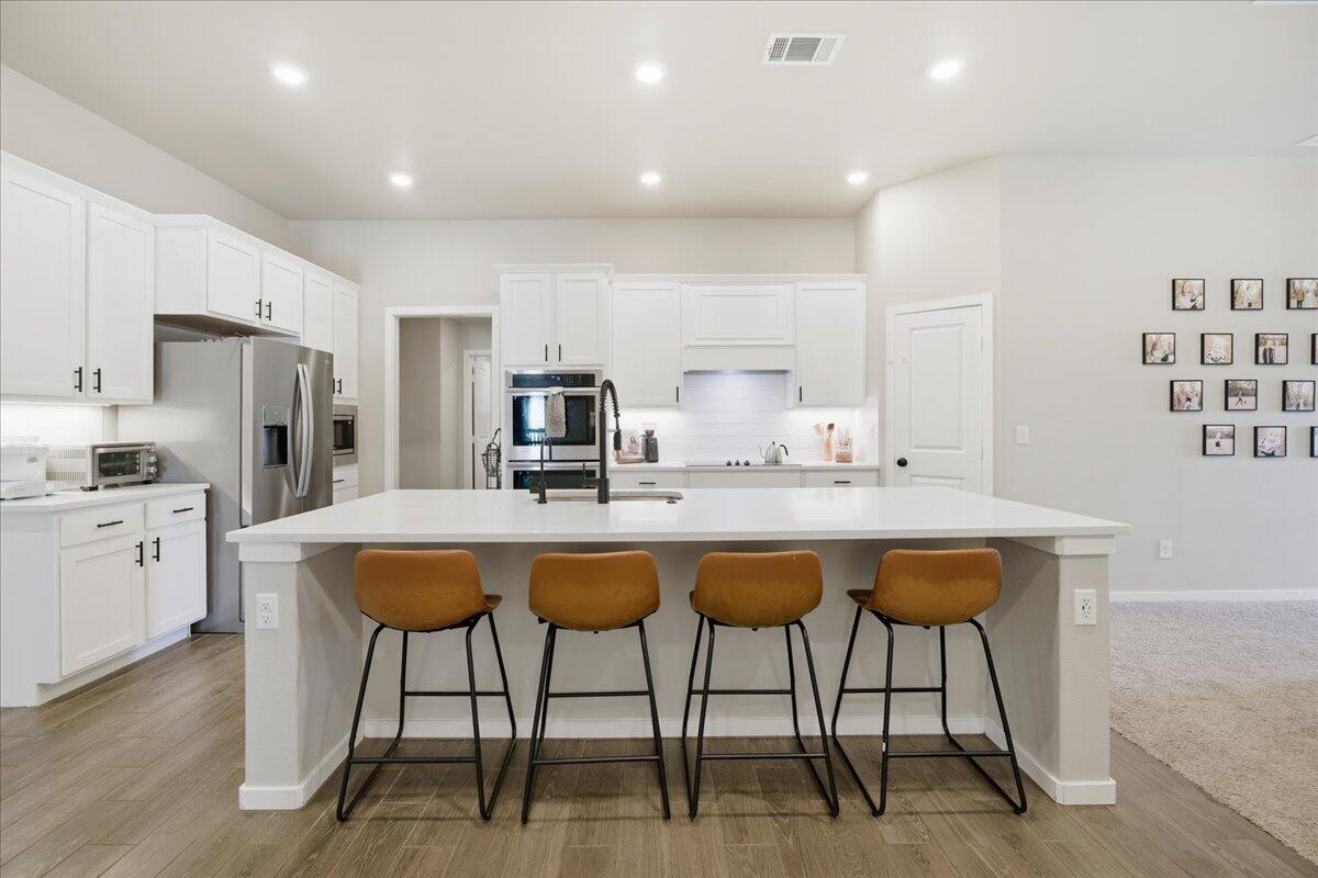 9807 Virginia Avenue Lubbock, TX 79424 - Photo 14 of 39 a kitchen with stainless steel appliances a dining table chairs and wooden floor