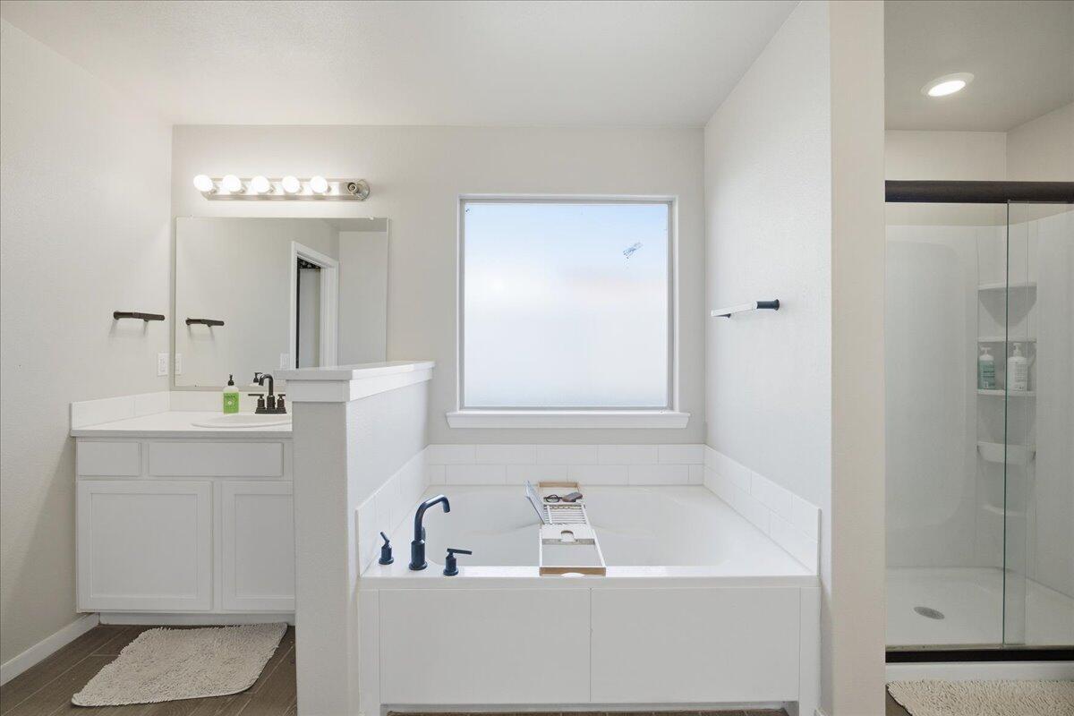 9807 Virginia Avenue Lubbock, TX 79424 - Photo 28 of 39 a bathroom with a tub a sink and mirror