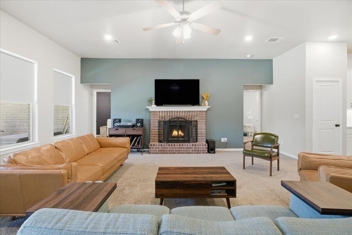 9807 Virginia Avenue Lubbock, TX 79424 - Photo 5 of 39 a living room with furniture a flat screen tv and a fireplace