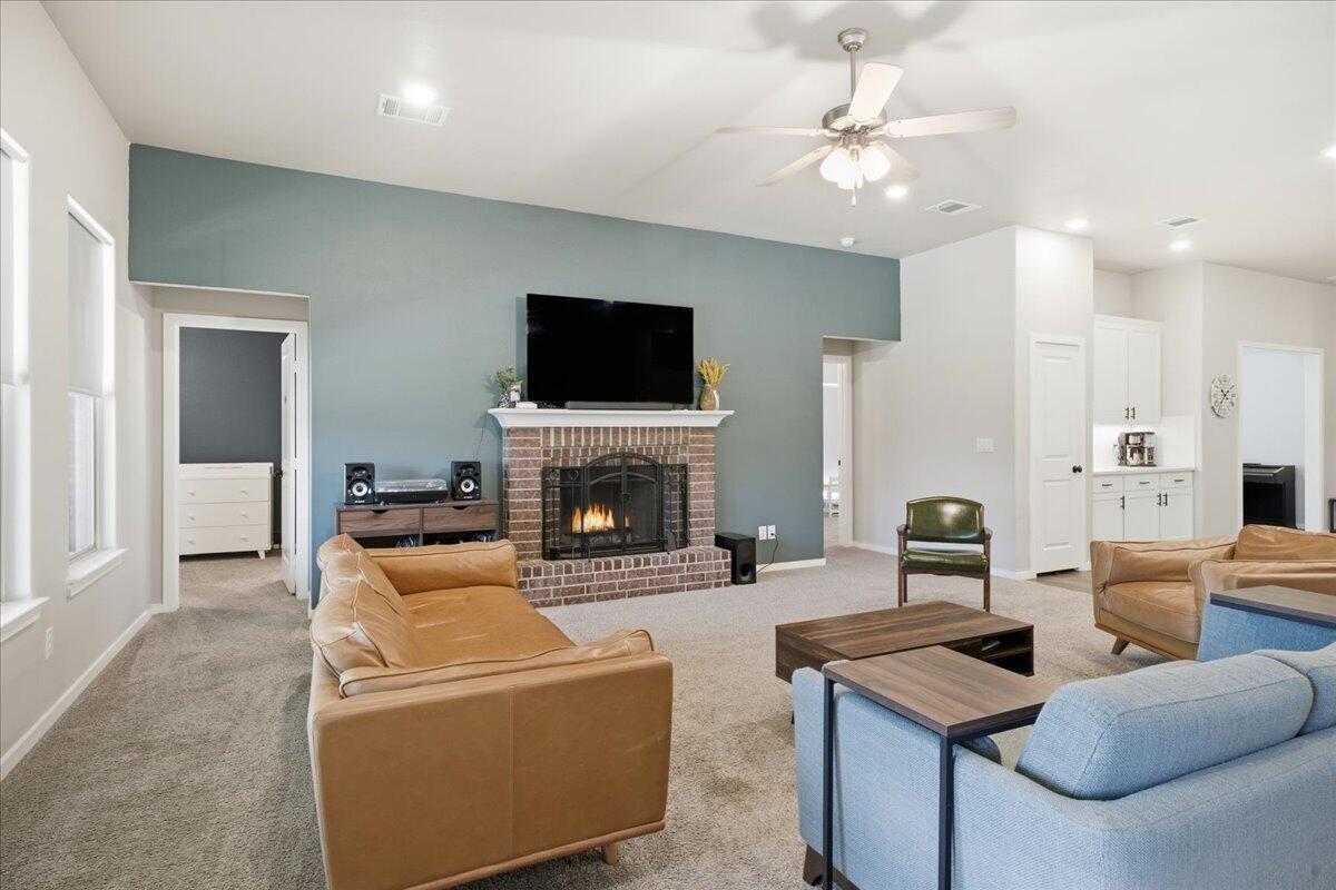 9807 Virginia Avenue Lubbock, TX 79424 - Photo 6 of 39 a living room with furniture a fireplace and a flat screen tv
