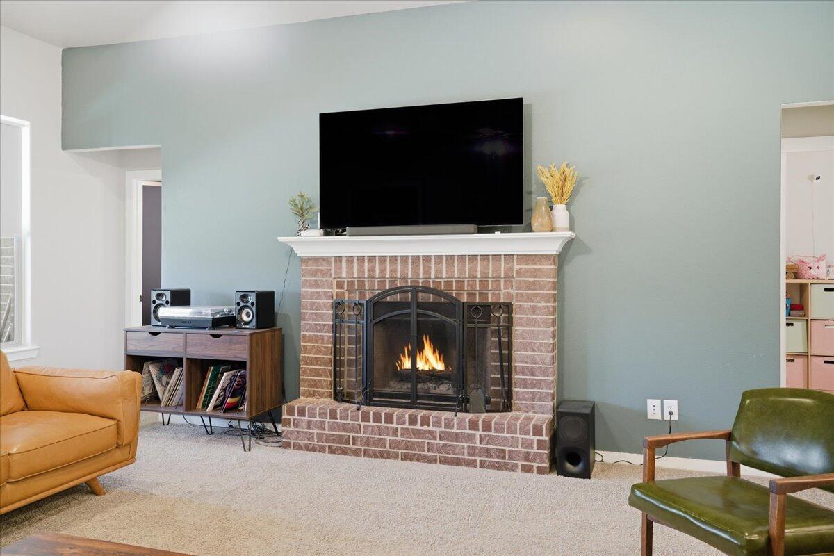 9807 Virginia Avenue Lubbock, TX 79424 - Photo 7 of 39 a living room with furniture a flat screen tv and a fireplace