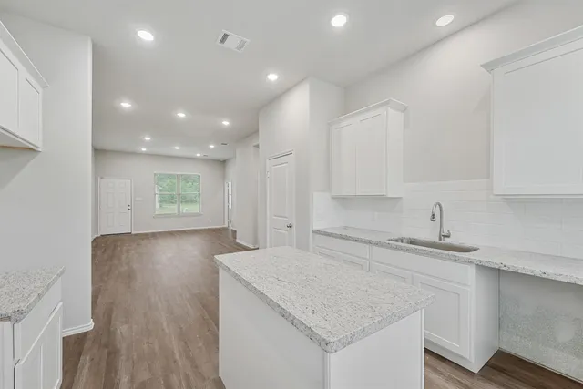 a kitchen with a sink microwave and cabinets