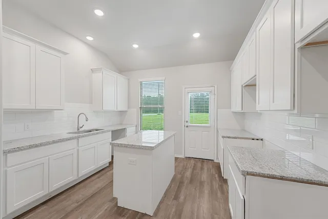 a kitchen with a sink stove and cabinets