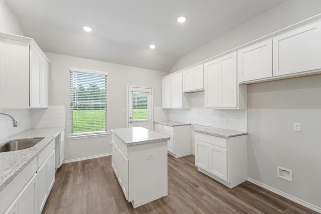 a kitchen with sink cabinets and wooden floor