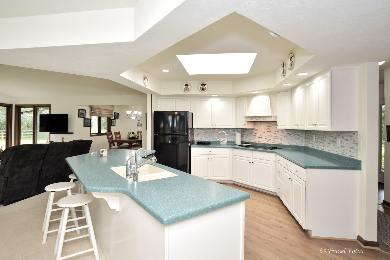 7405 Maxon Road Harvard, IL 60033 - Photo 10 of 30 a large kitchen with kitchen island a refrigerator a stove a sink a dining table and chairs with wooden floor