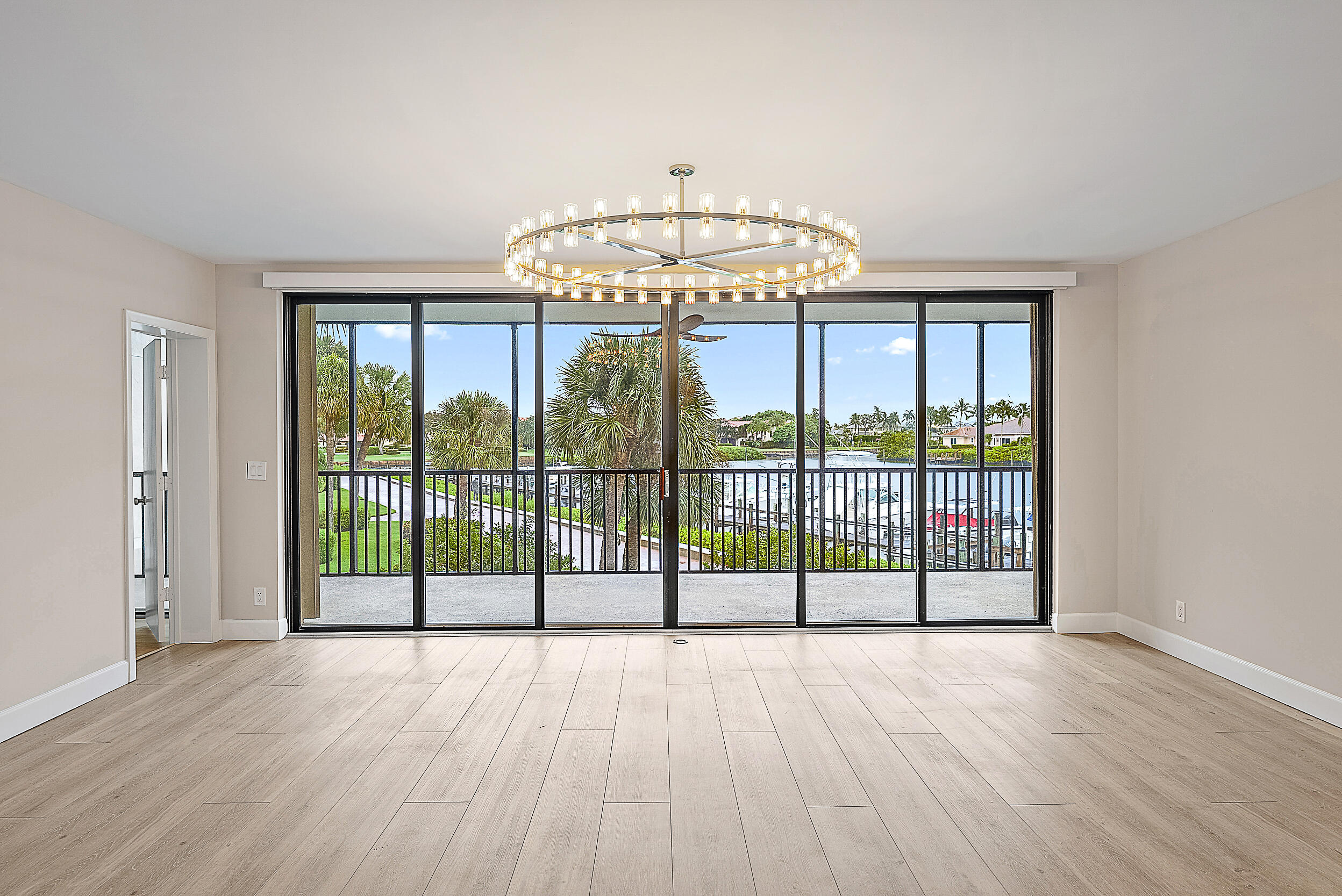 16910 Bay Street, Unit E204 Jupiter, FL 33477 - Photo 15 of 27 an empty room with wooden floor and balcony