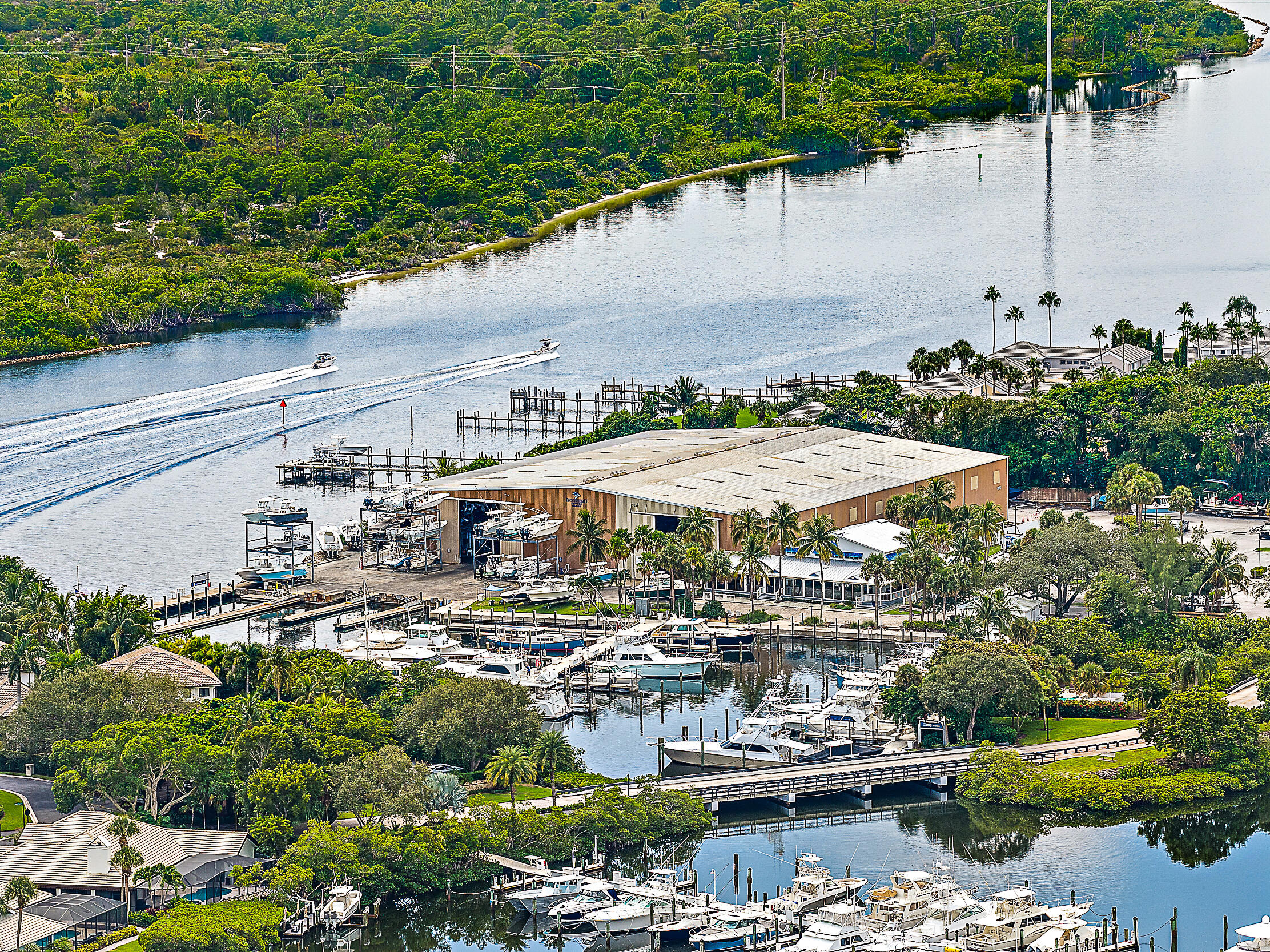 16910 Bay Street, Unit E204 Jupiter, FL 33477 - Photo 18 of 27 a view of a lake with a patio and lawn chairs under an umbrella
