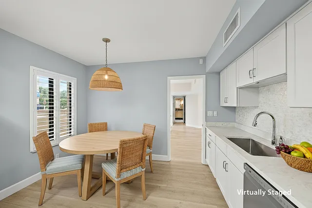 a view of a dining room with furniture a chandelier and wooden floor