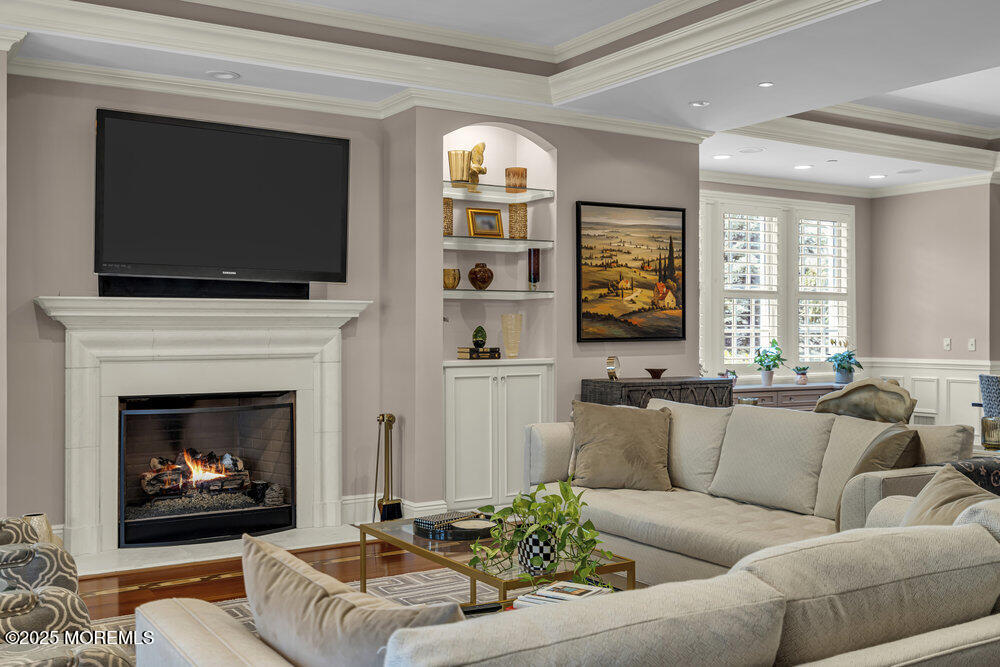 1222 Oval Road Manasquan, NJ 08736 - Photo 17 of 77 a living room with furniture a flat screen tv and a fireplace