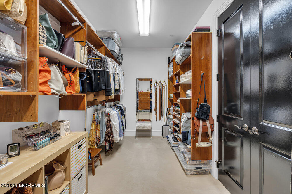 1222 Oval Road Manasquan, NJ 08736 - Photo 49 of 77 a view of walk in closet with clothes and shoes