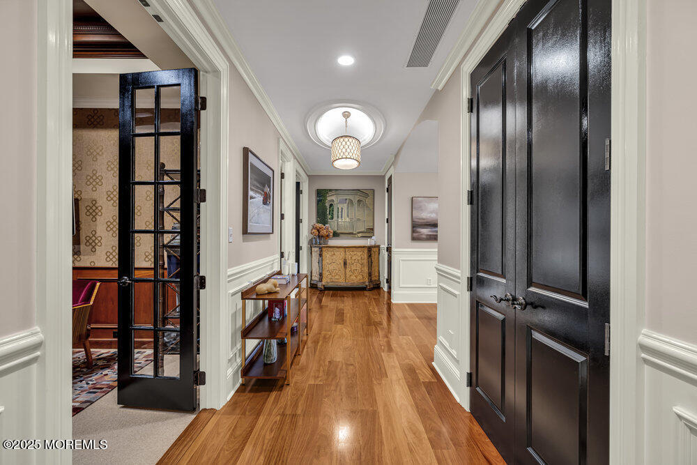 1222 Oval Road Manasquan, NJ 08736 - Photo 7 of 77 a view of a hallway with wooden floor and stairs