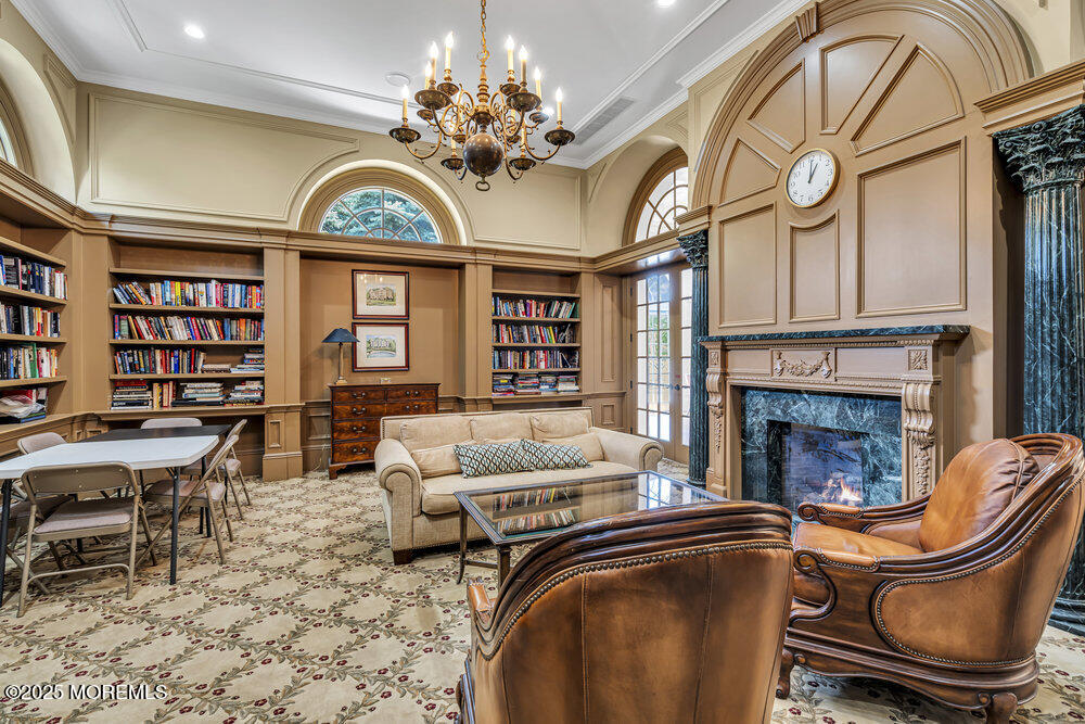 1222 Oval Road Manasquan, NJ 08736 - Photo 72 of 77 a living room with furniture a chandelier and a fireplace