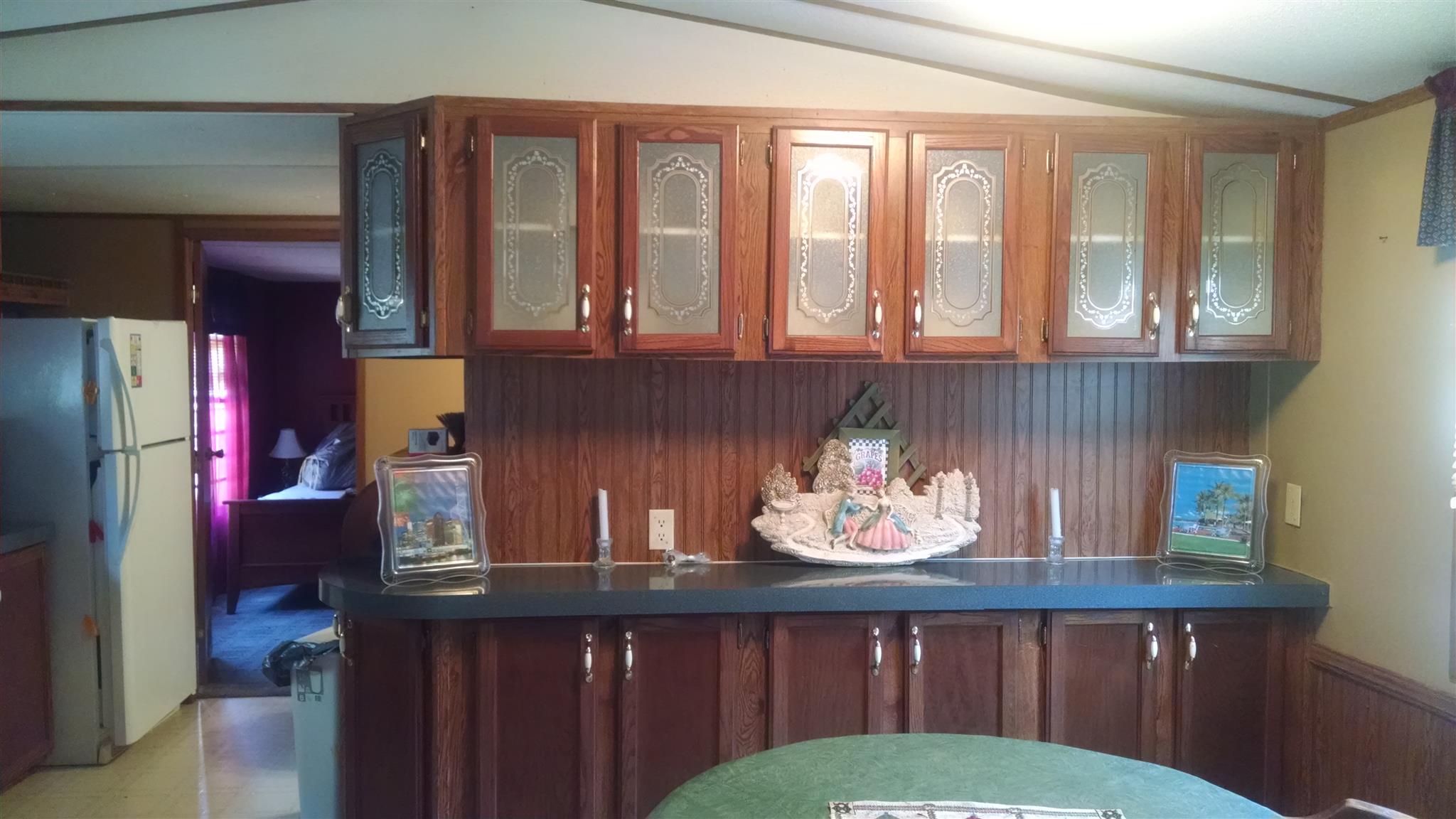 1535 Maddox Road Centerville, TN 37033 - Photo 6 of 26 a kitchen with a refrigerator a stove and wooden cabinets